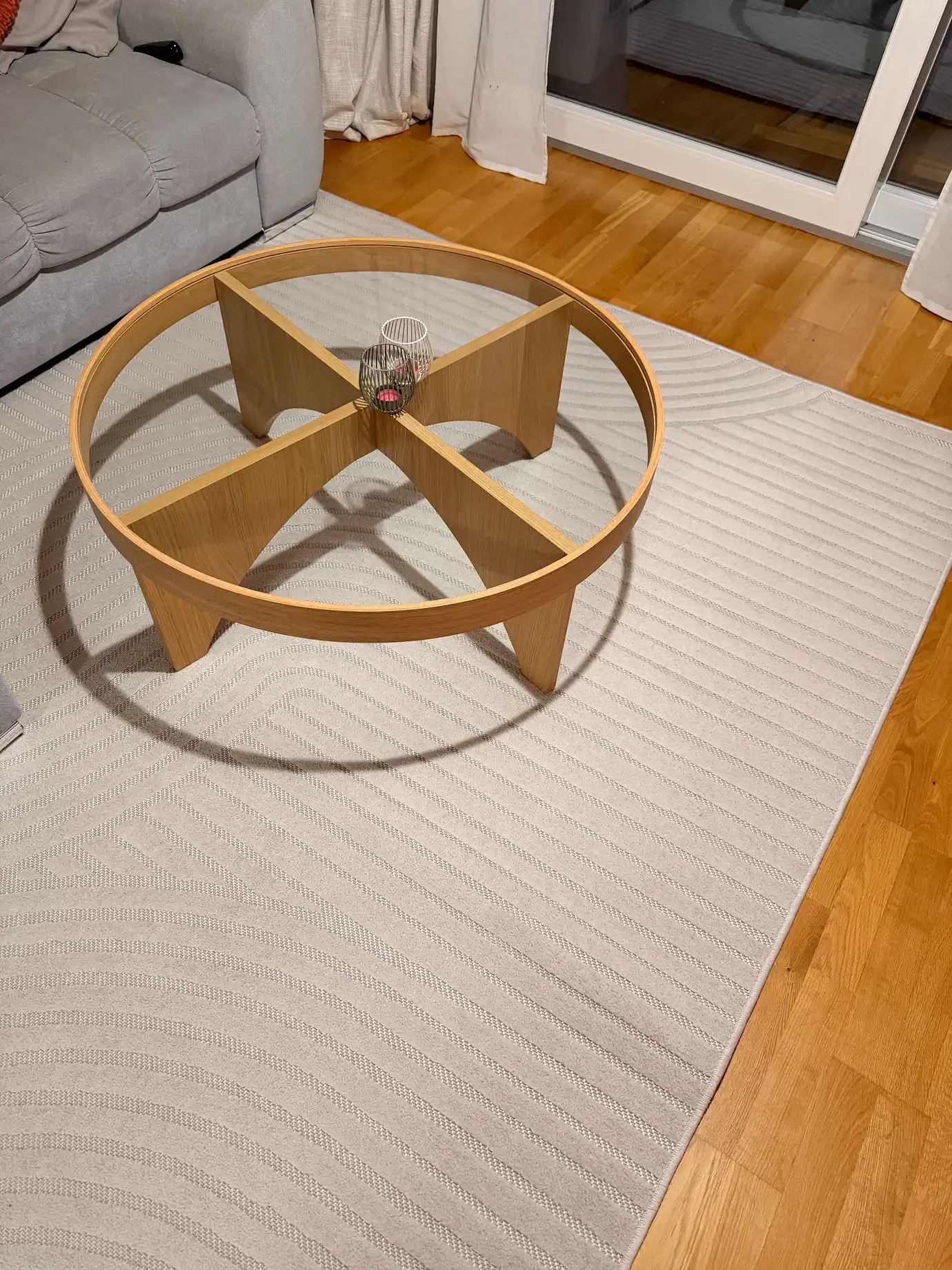 Tapis clair à motifs dans un salon avec canapé et table basse en bois